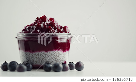A simple serving of chia pudding layered with blueberry compote, presented in a sleek jar against a white background, concept of healthy eating A simple serving of chia pudding layered with blueberry compote, presented in a sleek jar against a white background, concept of healthy eating 126395713