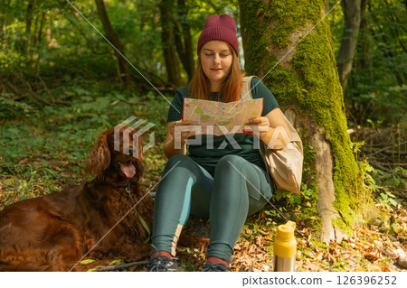 Woman with Map and Dog Resting in Forest 126396252