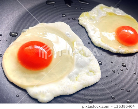 Fried eggs cooking in a frying pan Fried eggs cooking in a frying pan 126396404