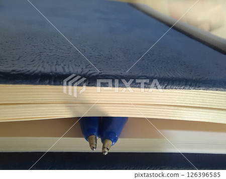Two ballpen inside notebook pages 126396585