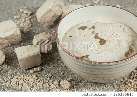 Activation of wet fresh yeast in warm water with sugar. 126396615