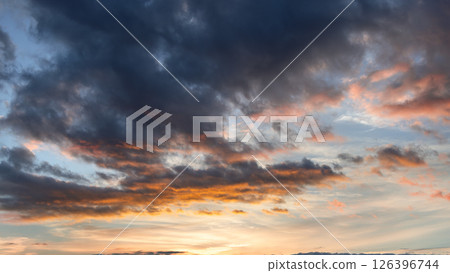 Morning light filters through layered clouds, blending warm golden and soft pink hues Morning light filters through layered clouds, blending warm golden and soft pink hues 126396744