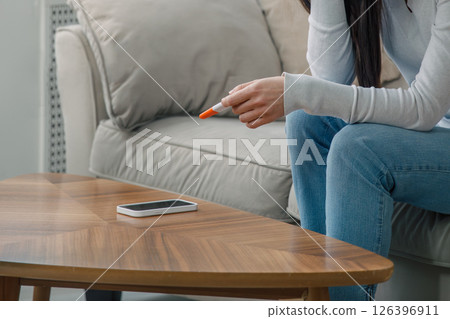 Anonymous Woman Holding a Pregnancy Test, Expressing Stress and Uncertainty 126396911