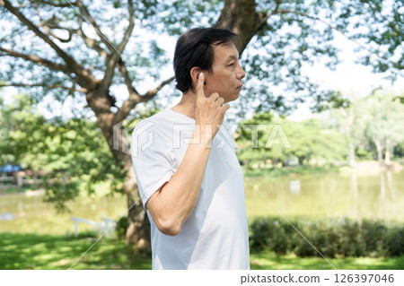 Wellness and Fitness. Senior man stretching in park for healthy lifestyle. Wellness and Fitness. Senior man stretching in park for healthy lifestyle. 126397046