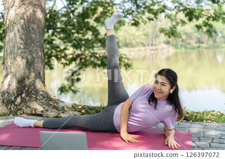 Wellness and Fitness. Woman stretching and practicing yoga by the lake. Wellness and Fitness. Woman stretching and practicing yoga by the lake. 126397072