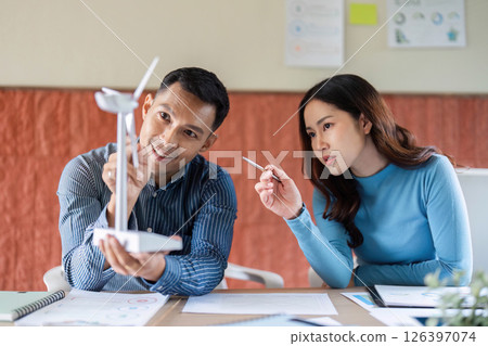 ESG Business Strategy. Professionals analyzing renewable energy models in a collaborative workspace. ESG Business Strategy. Professionals analyzing renewable energy models in a collaborative workspace. 126397074
