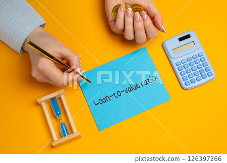 Loan to Value LTV ratio concept. Financial term used to express the ratio of a loan to the value of an asset purchased. Business and finance. A woman writes in notes Loan to Value LTV ratio concept. Financial term used to express the ratio of a loan to the value of an asset purchased. Business and finance. A woman writes in notes 126397266