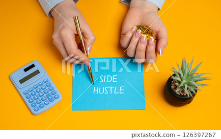 Side hustle concept. Secondary job or business venture that a person takes on in addition to their primary source of income. A woman writes in a notebook and holds coins in her hands Side hustle concept. Secondary job or business venture that a person takes on in addition to their primary source of income. A woman writes in a notebook and holds coins in her hands 126397267