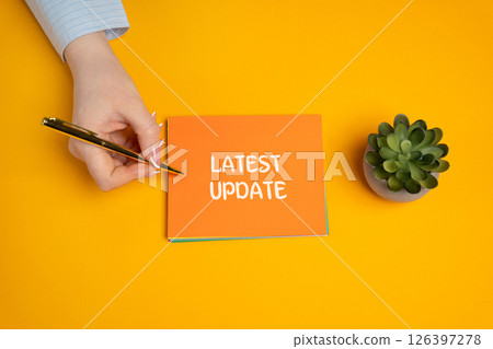 Notes with inscription Latest Update. Updating the version of software components program. New data and information. A woman writes a note in a notebook 126397278