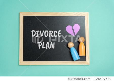 Divorce plan concept. Structured agreement outlining the terms of a separation, including finances, property, and child custody. Board with the inscription and wooden little figurines 126397320
