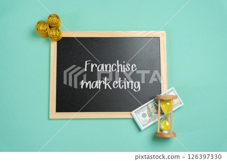 Franchise marketing concept. Strategies and actions used to promote a franchise brand and attract both customers and potential franchisees. Board with inscription and money 126397330