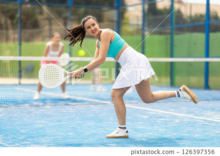Woman standing on court and playing paddle tennis 126397356
