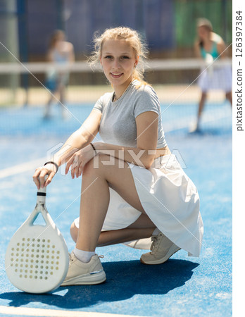 Woman sitting on court with racket 126397384