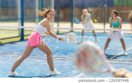 Woman playing with other paddle tennis players 126397446