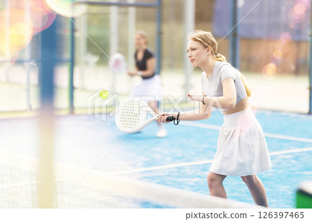Young woman playing doubles padel tennis Young woman playing doubles padel tennis 126397465
