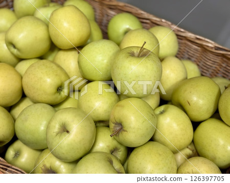 A vibrant and colorful display of fresh, crisp green apples organized neatly in a bustling market settings. Close-up. A vibrant and colorful display of fresh, crisp green apples organized neatly in a bustling market settings. Close-up. 126397705