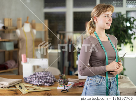 Young female dressmaker welcoming clients in sewing workshop Young female dressmaker welcoming clients in sewing workshop 126397706