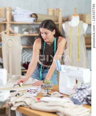 Woman tailor making chalk marks on fabric Woman tailor making chalk marks on fabric 126397746