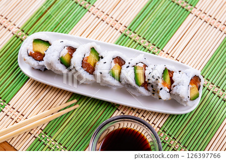 On table there is plate with set of sushi - uramaki rolls california roll with chees On table there is plate with set of sushi - uramaki rolls california roll with chees 126397766