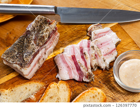 Traditional russian and ukrainian food, salted smoked pork bacon with horseradish on wooden cutting board 126397770