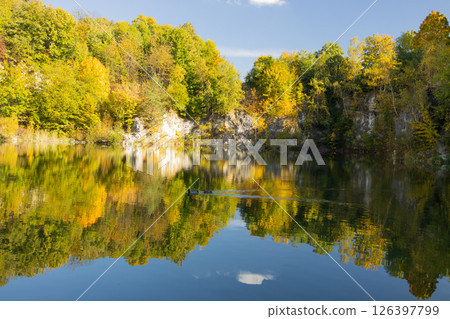 Autumn forest lake in Poland. Autumn lake in autumn forest. The autumn foliage of the trees is reflected in the lake water 126397799