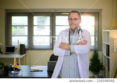 Portrait of experienced male physician with arms crossed in a bright workspace Portrait of experienced male physician with arms crossed in a bright workspace 126398048