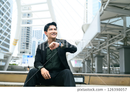 Young entrepreneur checking the time, waiting for appointment in financial district Young entrepreneur checking the time, waiting for appointment in financial district 126398057