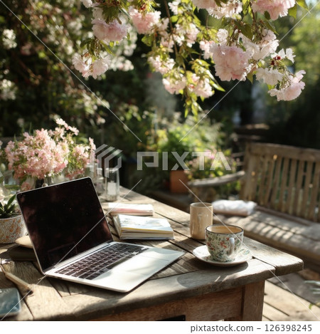 Laptop and Tea on Wooden Table in a Flower Garden Laptop and Tea on Wooden Table in a Flower Garden 126398245