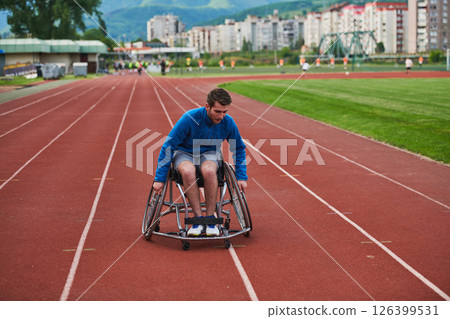 A person athlete with disability in a wheelchair racing on an outdoor track. 126399531