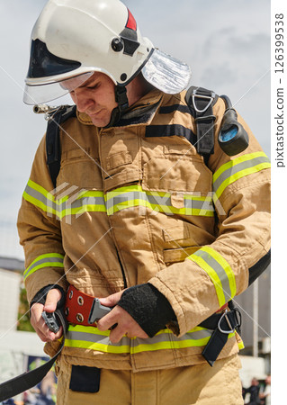 A firefighter dons the essential components of their professional gear, embodying resilience, commitment, and readiness as they gear up for a hazardous firefighting mission, a testament to their A firefighter dons the essential components of their professional gear, embodying resilience, commitment, and readiness as they gear up for a hazardous firefighting mission, a testament to their 126399538