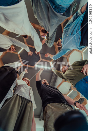 A group of young businessmen offer their hands together, symbolizing togetherness in the business world A group of young businessmen offer their hands together, symbolizing togetherness in the business world 126399539