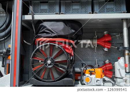 Close-up of essential firefighting equipment on a modern firetruck, showcasing tools and gear ready for emergency response to hazardous fire situations Close-up of essential firefighting equipment on a modern firetruck, showcasing tools and gear ready for emergency response to hazardous fire situations 126399541