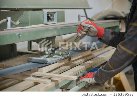 Close Up of Worker Carefully Cutting and Planing Wooden Pieces for Furniture in Wood Industry 126399552