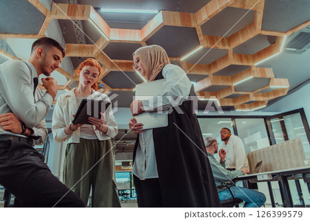 Young group of business people brainstorming together in a startup space, discussing business projects, investments, and solving challenges. Young group of business people brainstorming together in a startup space, discussing business projects, investments, and solving challenges. 126399579
