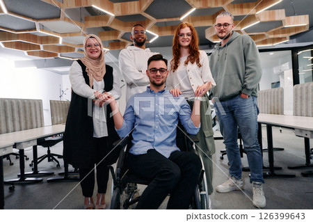 Young businessmen in a modern office extend a handshake to their business colleague in a wheelchair, showcasing inclusivity, support, and unity in the corporate environment. 126399643