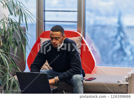 Overtime working. African American man with closed eyes is resting at work at laptop. Tired male programmer taking a break due to overtime work. 126399666