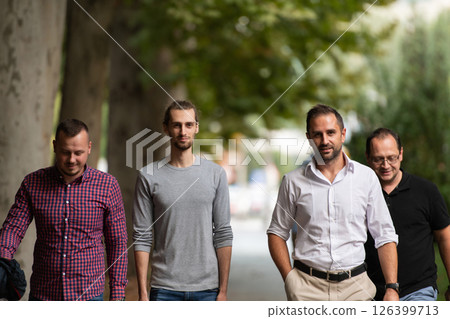 After a productive day at work, a group of diverse colleagues enjoy a leisurely stroll through a modern and natural urban setting After a productive day at work, a group of diverse colleagues enjoy a leisurely stroll through a modern and natural urban setting 126399713