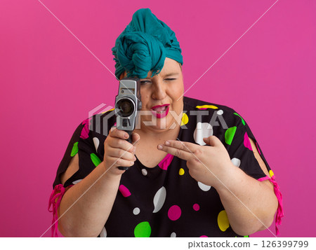 Colorful Woman Holding Vintage Camera in Quirky Studio Portrait 126399799
