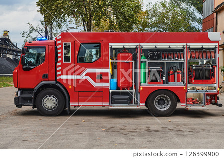 A state-of-the-art firetruck, equipped with advanced rescue technology, stands ready with its skilled firefighting team, prepared to intervene and respond rapidly to emergencies, ensuring the safety 126399900
