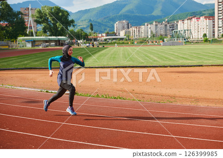 A muslim woman in a burqa sports muslim clothes running on a marathon course and preparing for upcoming competitions 126399985
