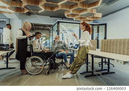 Young group of business people brainstorming together in a startup space, discussing business projects, investments, and solving challenges. 126400003