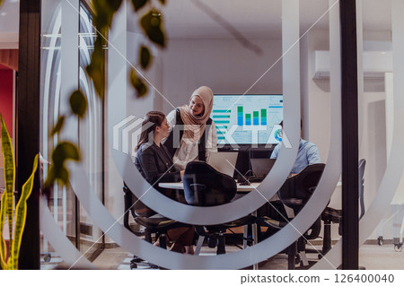 A diverse group of businessmen collaborates and tests a new virtual reality technology, wearing virtual glasses, showcasing innovation and creativity in their futuristic workspace 126400040