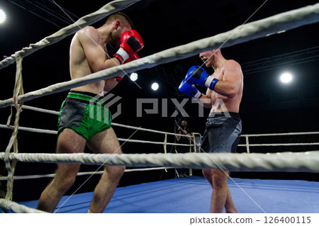 Fierce boxing match showcases athletes' power and skill. 126400115
