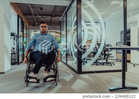 In a large modern corporation, a determined businessman in a wheelchair navigates through a hallway, embodying empowerment and inclusivity in the corporate world. 126400122
