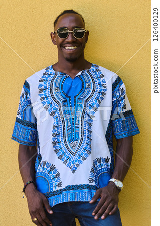 Sudanese Tradition Meets Modern Youth: African American Teen in Vibrant Traditional Attire Against a Yellow Backdrop Sudanese Tradition Meets Modern Youth: African American Teen in Vibrant Traditional Attire Against a Yellow Backdrop 126400129