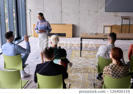 A businesswoman leader guiding a meeting with her colleagues, discussing business challenges, marketing strategies, and new plans for growth and success 126400159