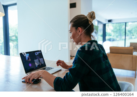 Woman sitting in living room using laptop looking at cam talk by video call with business friend relatives, head shot. Job interview answering questions Woman sitting in living room using laptop looking at cam talk by video call with business friend relatives, head shot. Job interview answering questions 126400164