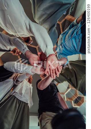A group of young businessmen offer their hands together, symbolizing togetherness in the business world 126400199