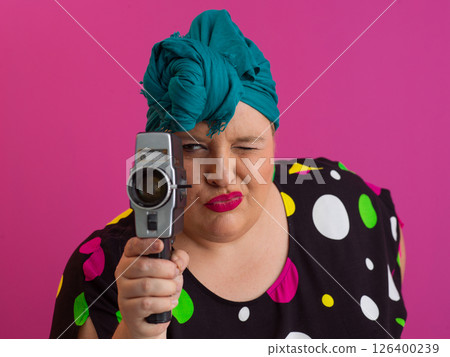 Colorful Woman Holding Vintage Camera in Quirky Studio Portrait 126400239