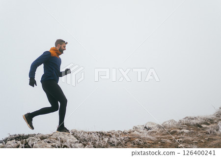 Man Climbing Rocky Hill in Fog Man Climbing Rocky Hill in Fog 126400241